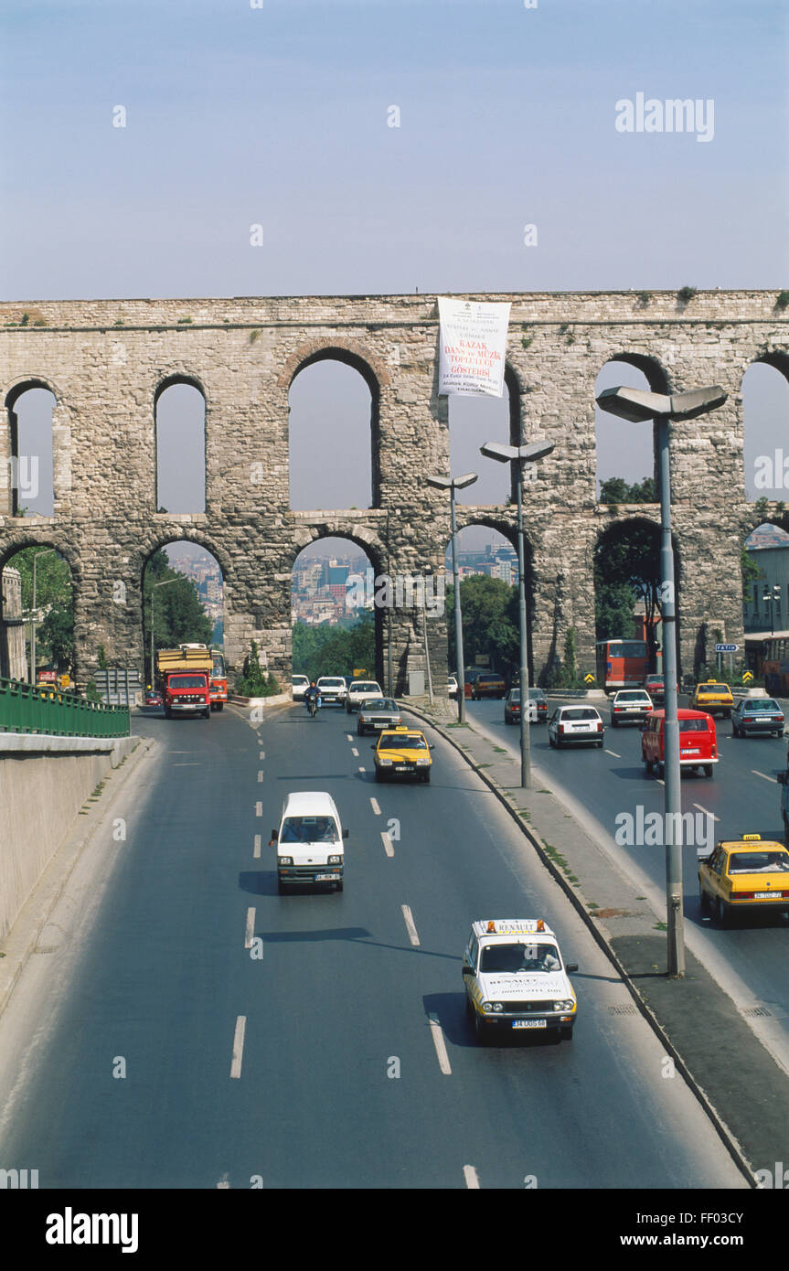 Turkey, Istanbul, 4th-century Valens Aqueduct crossing Ataturk Bulvari, vehicles on busy road, cityscape visible through arches in background. Stock Photo