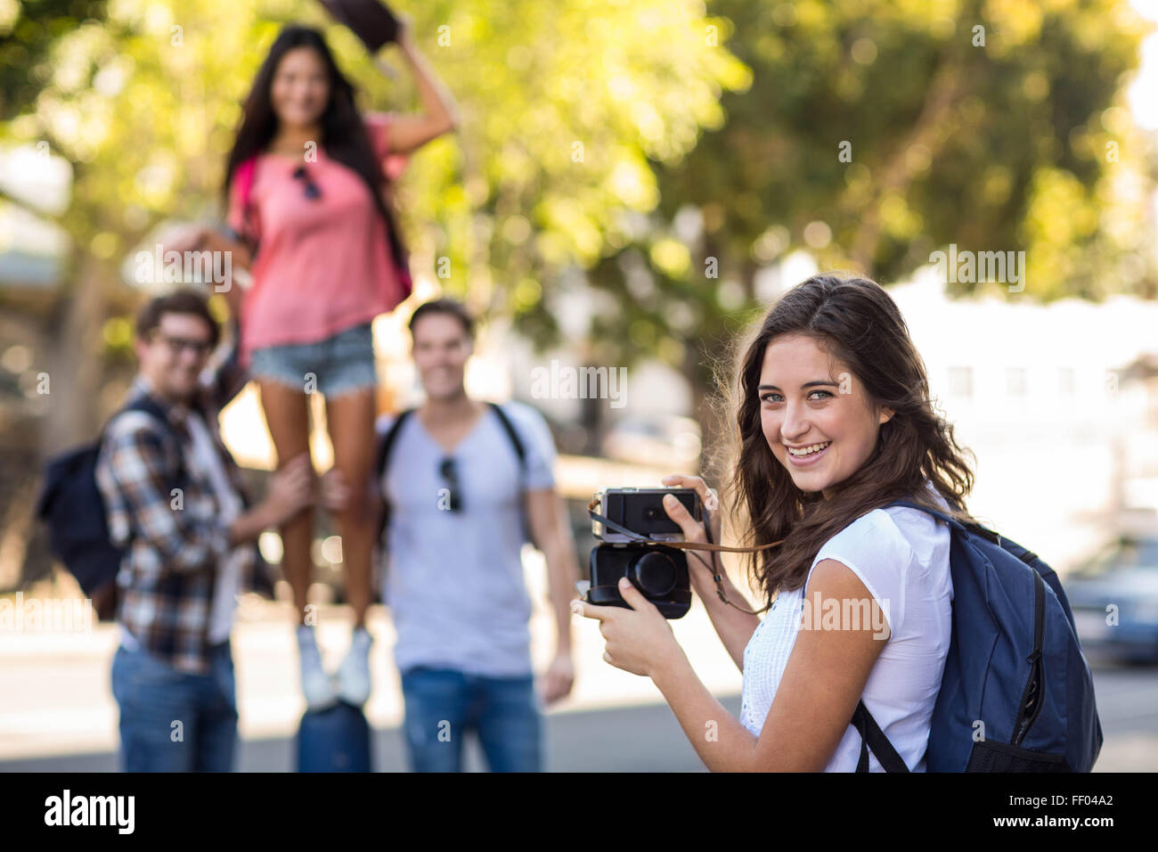 Hip woman taking picture of her friends Stock Photo