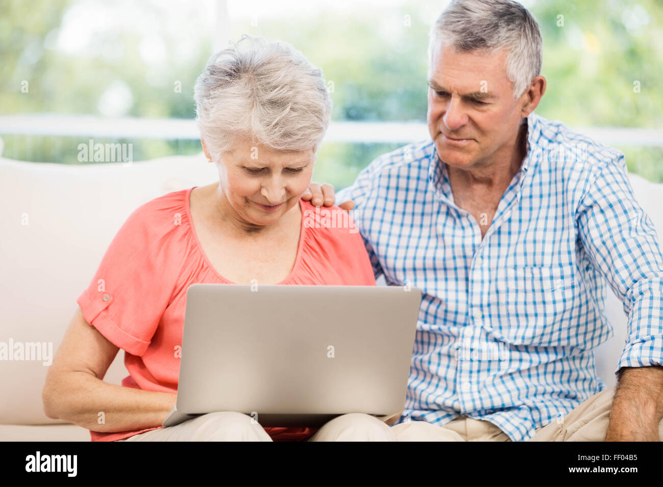 Smiling senior couple using laptop Stock Photo