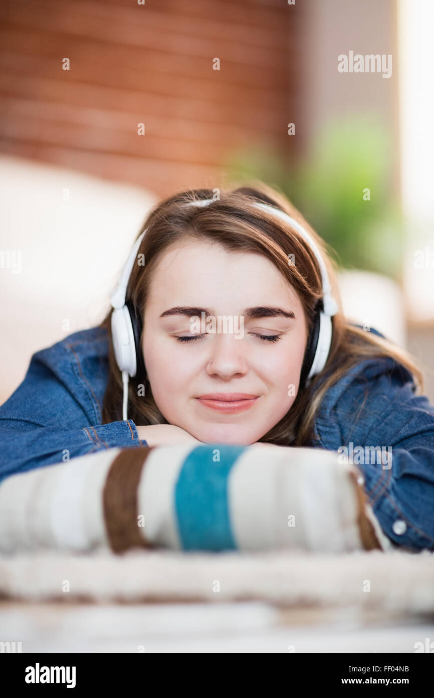 Pretty woman listening music lying on the floor Stock Photo - Alamy