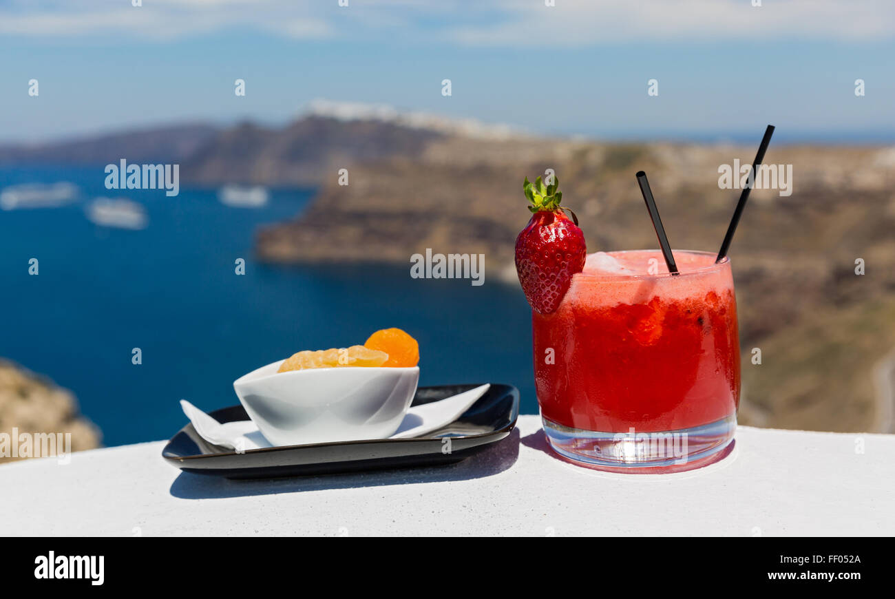Glass of cold strawberry cocktail and orange on the background of a sea Bay Stock Photo