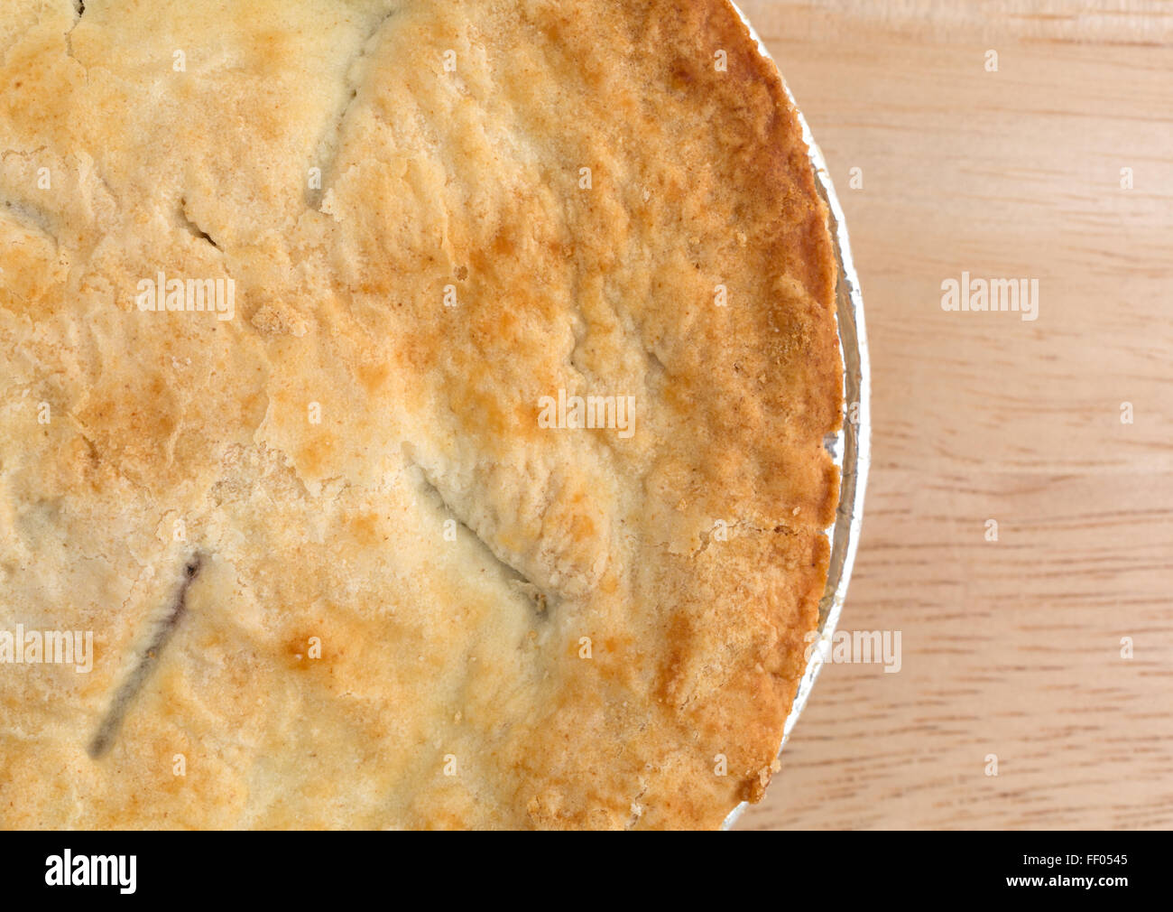 Top close view of a small personal size fruit filled pie in a tinfoil