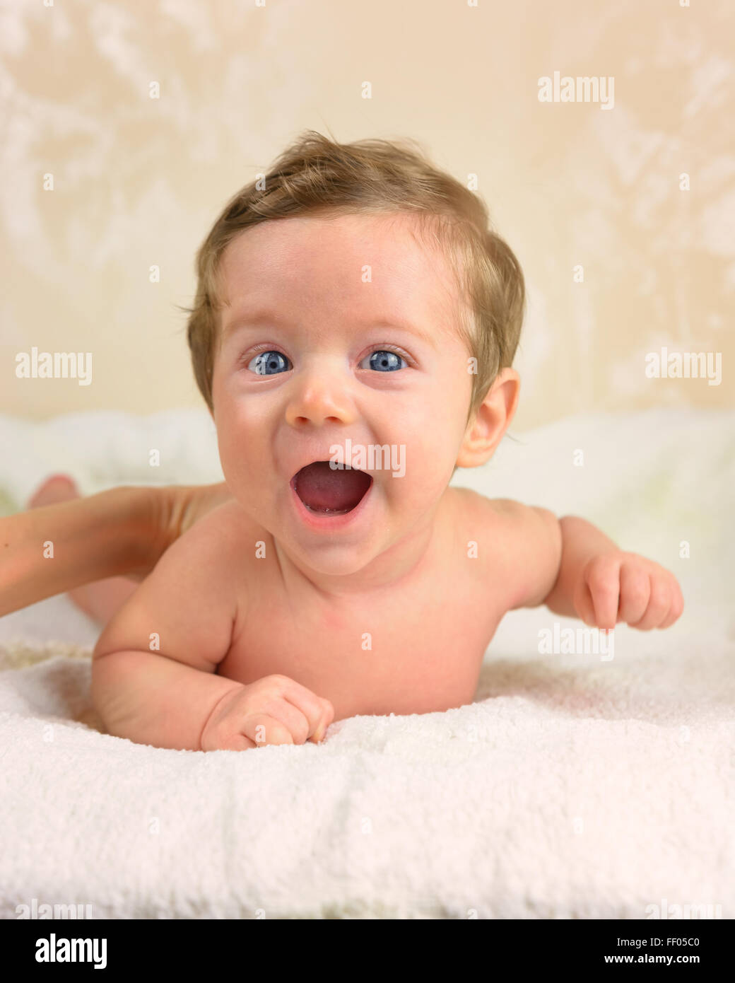 Cute infant boy lie prone and smiling. Stock Photo