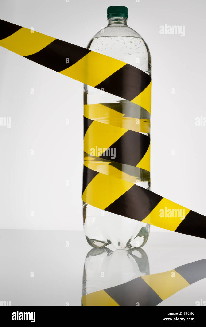 Water bottle with yellow and black striped security tape. Representing
