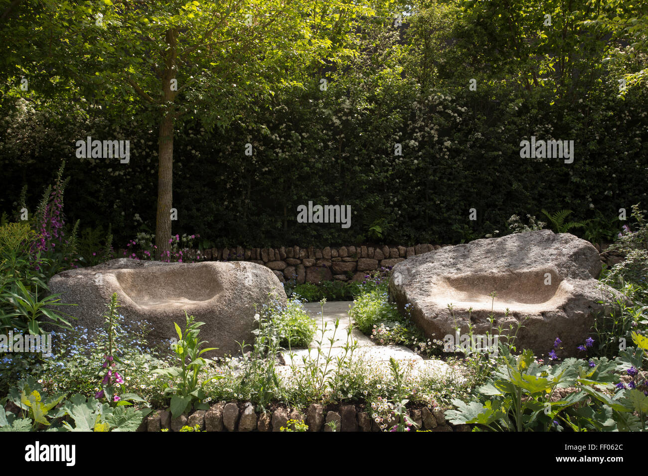 The Brewin Dolphin Garden - granite stone carved seats on patio area, dry stone wall -Designer Darren Hawkes Lan Stock Photo