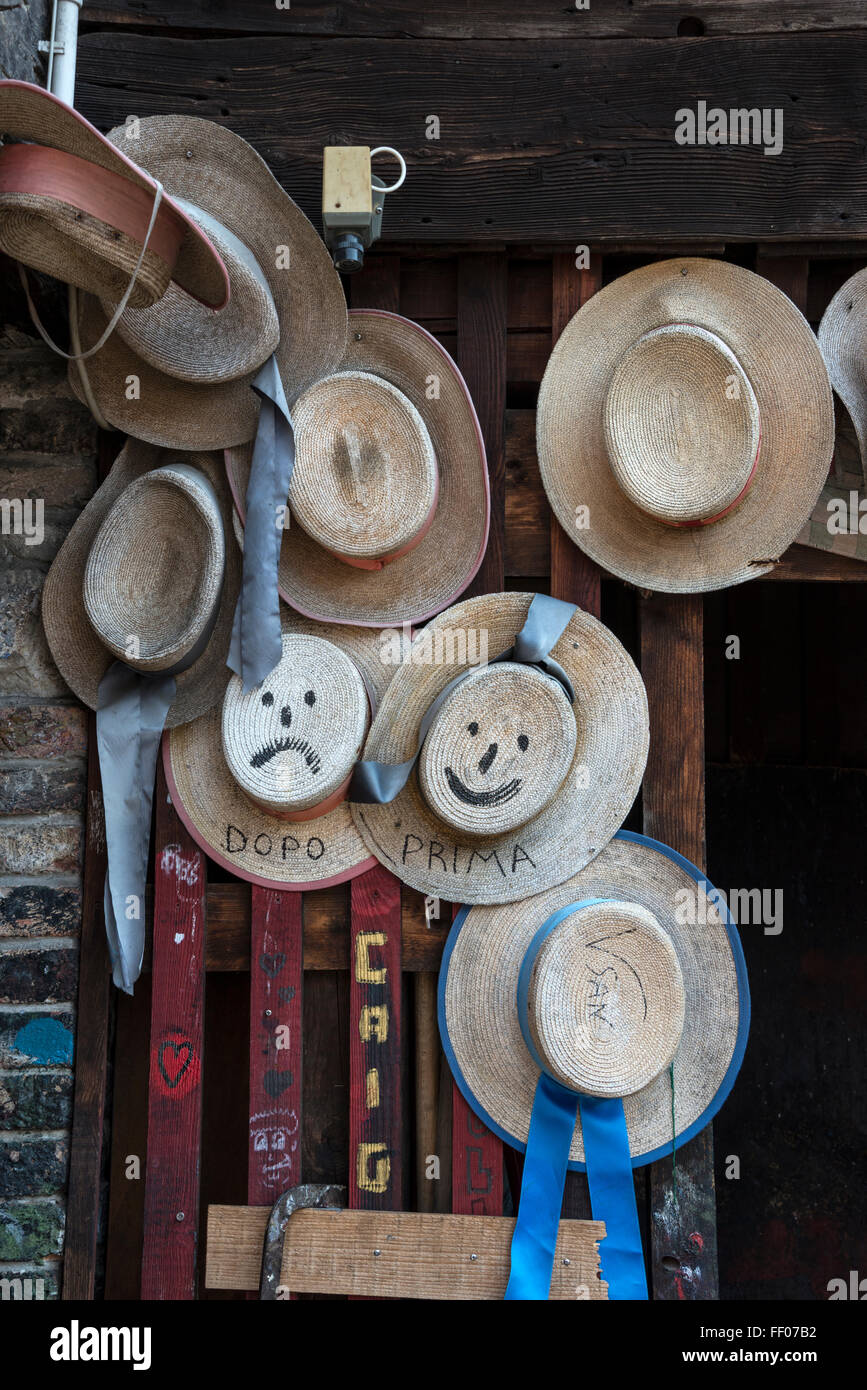 A collection of gondolier hats hang on a door in the gondola boat builder's yard at Squero di San Trovaso on the bank of the Rio de S Trovaso. Stock Photo