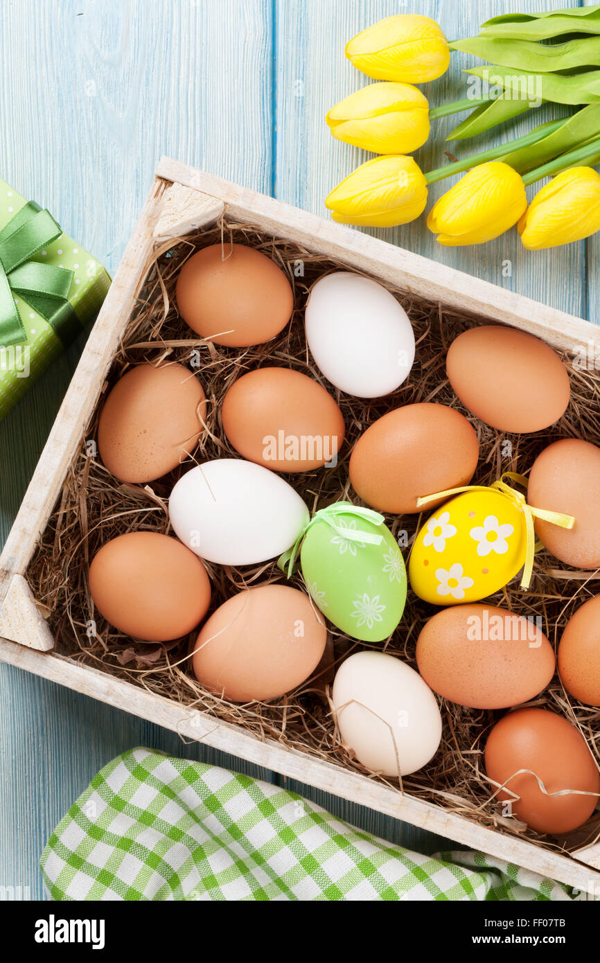 Easter eggs and yellow tulips over wooden background Stock Photo - Alamy