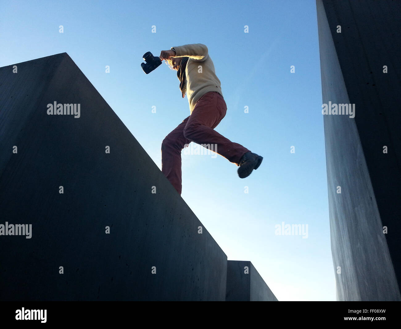 Photographer Leaping on Cement Structures Photographer Leaping on Cement Structure Stock Photo