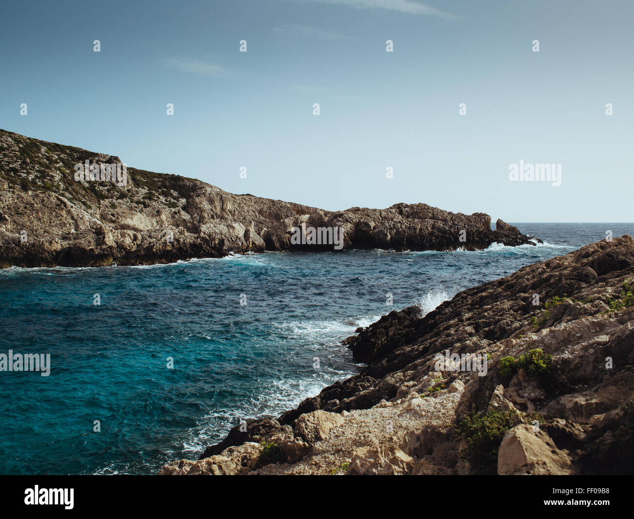 An ocean inlet with blue waters, surrounded by rocky shores. The inlet ...