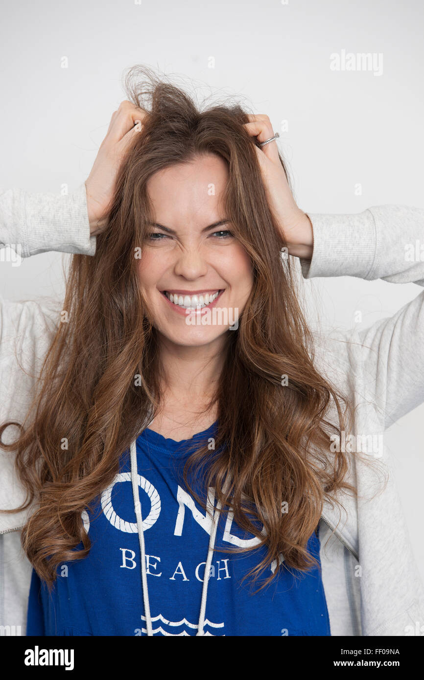 woman with hands in her hair with excited and happy expression Stock Photo