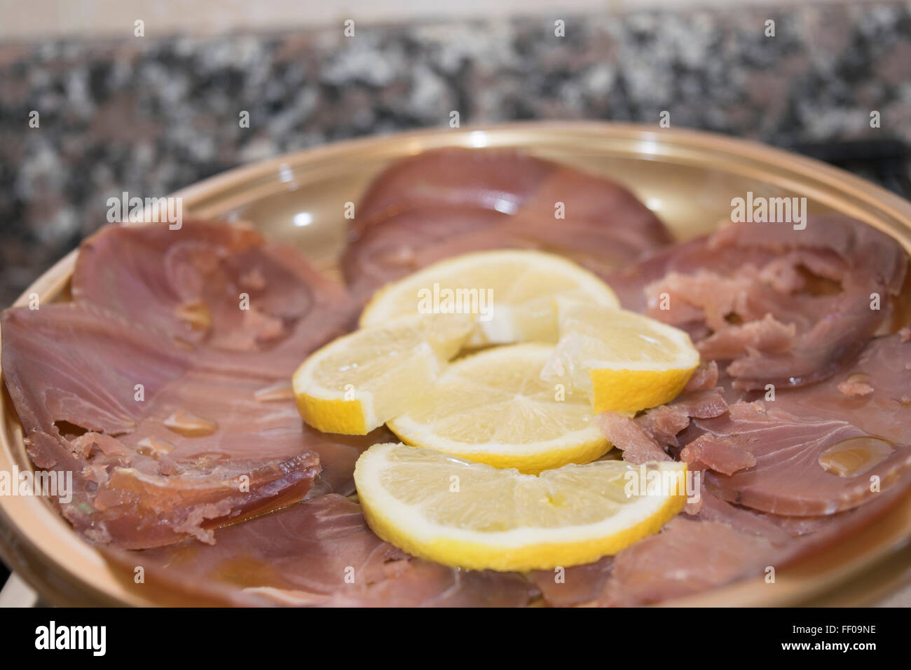 slices of smoked tuna with slices of lemon for appetiser Stock Photo