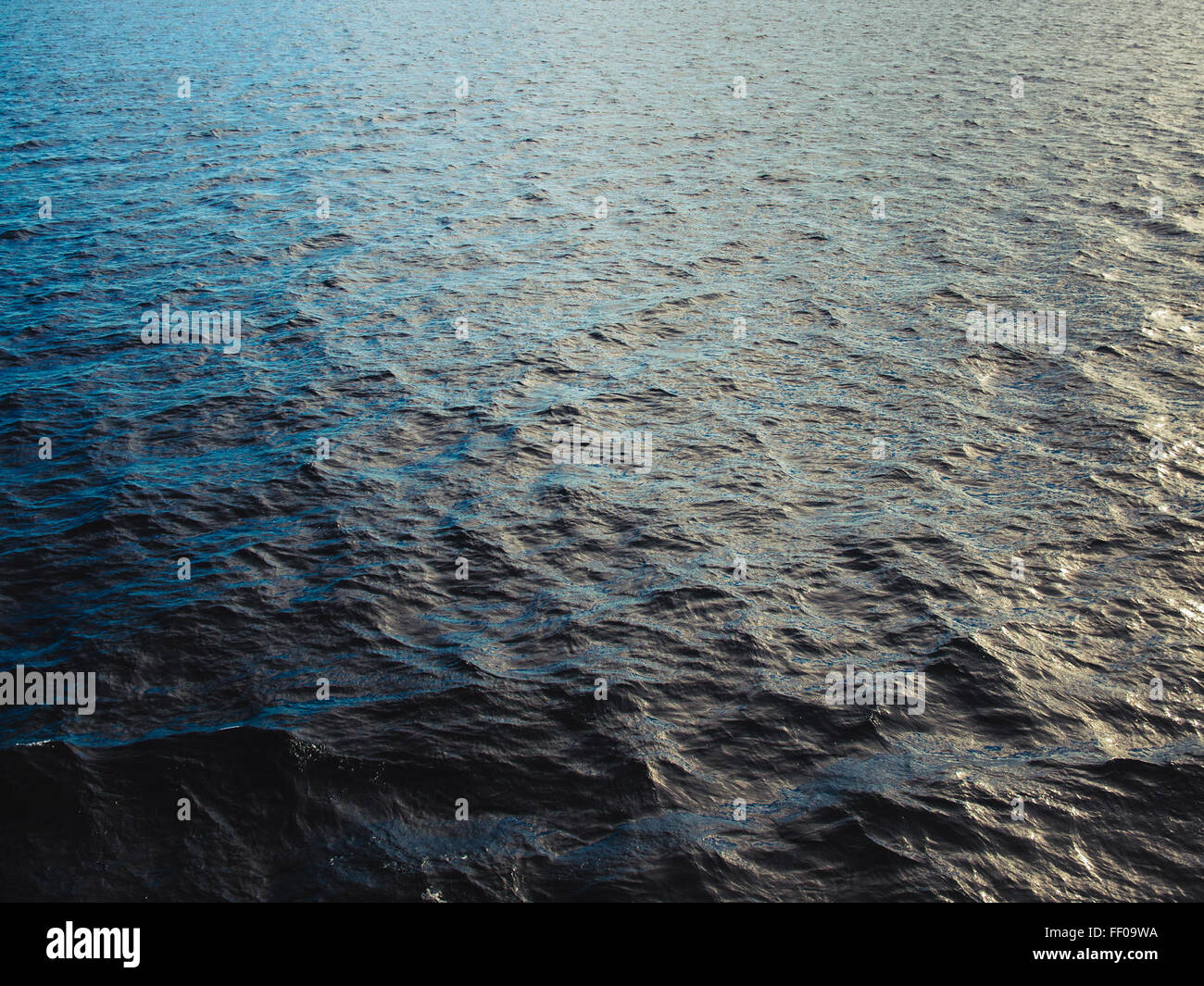 A close-up texture of ocean water, with waves and ripples creating ...