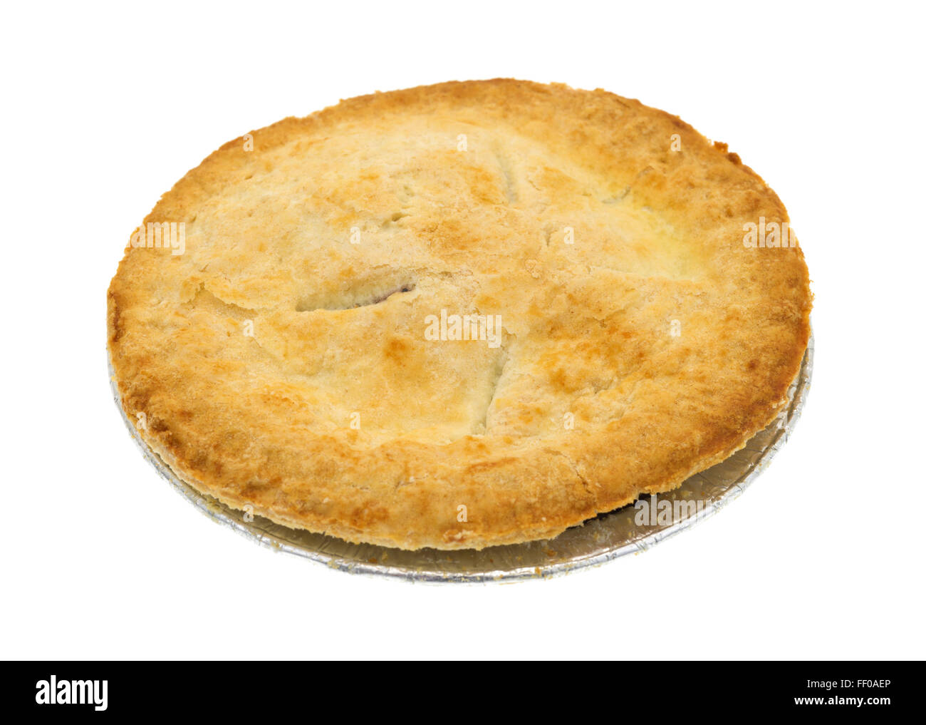 Side view of a small personal size fruit filled pie in a tinfoil dish isolated on a white background. Stock Photo