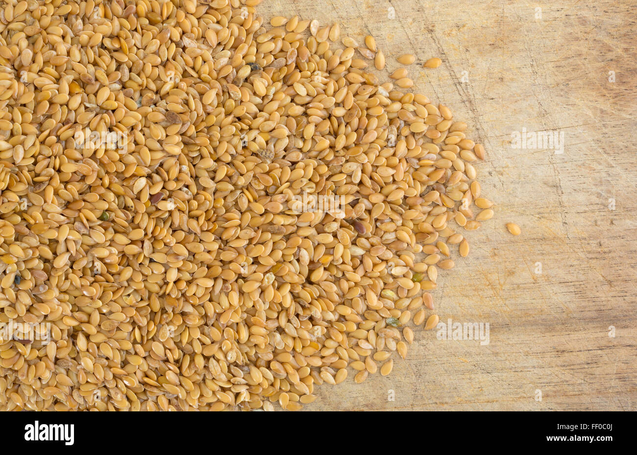 Top view of a portion of organic golden flaxseed spilled onto an old