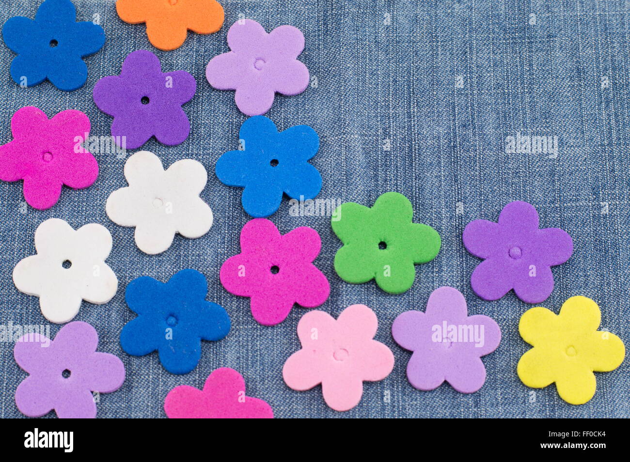 colorful artificial flowers on denim background Stock Photo