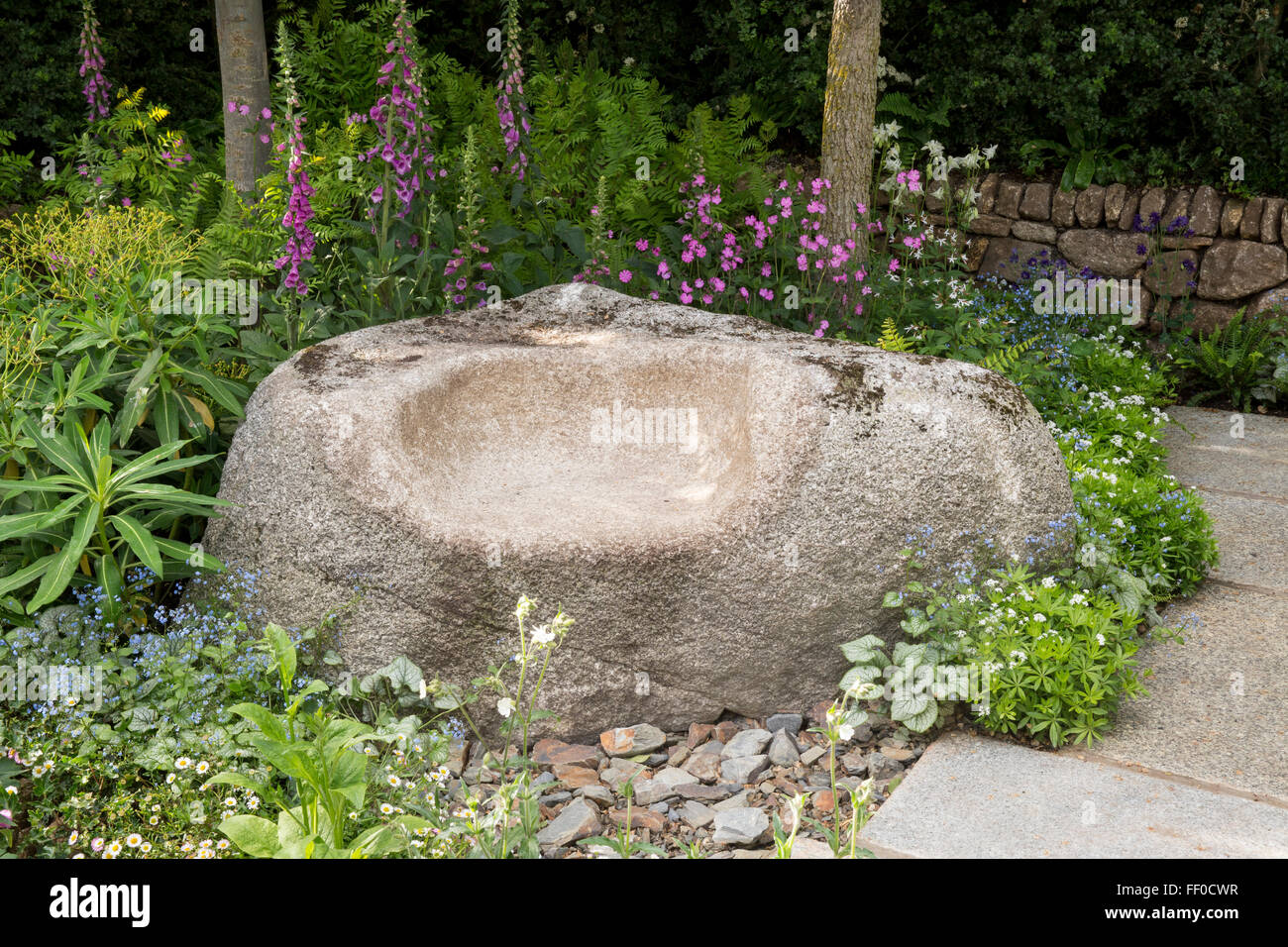 The Brewin Dolphin Garden - granite stone carved seats on patio area, dry stone wall, Darren Hawkes Stock Photo