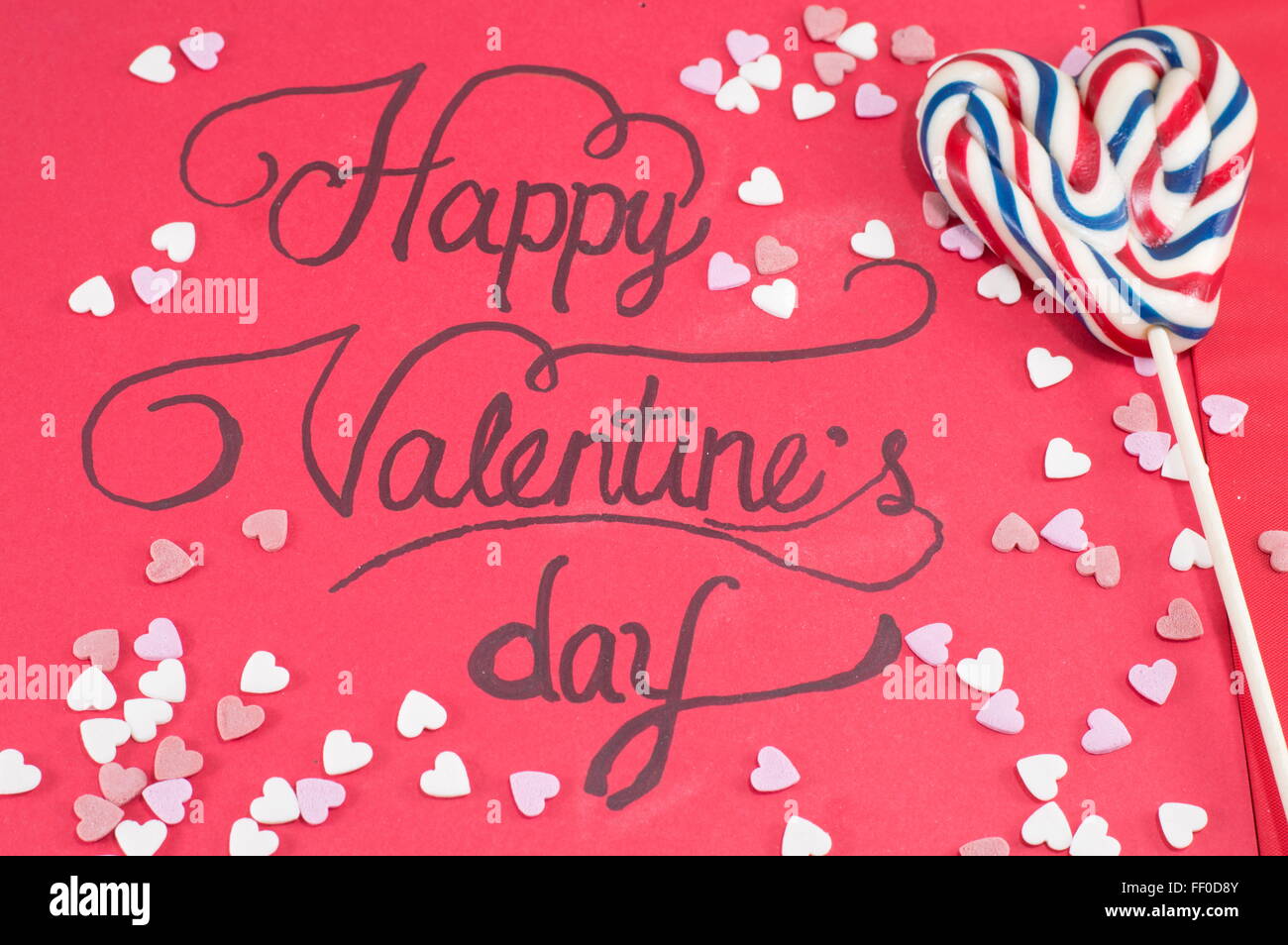 handwritten Valentines card and a heart shaped lollipop Stock Photo