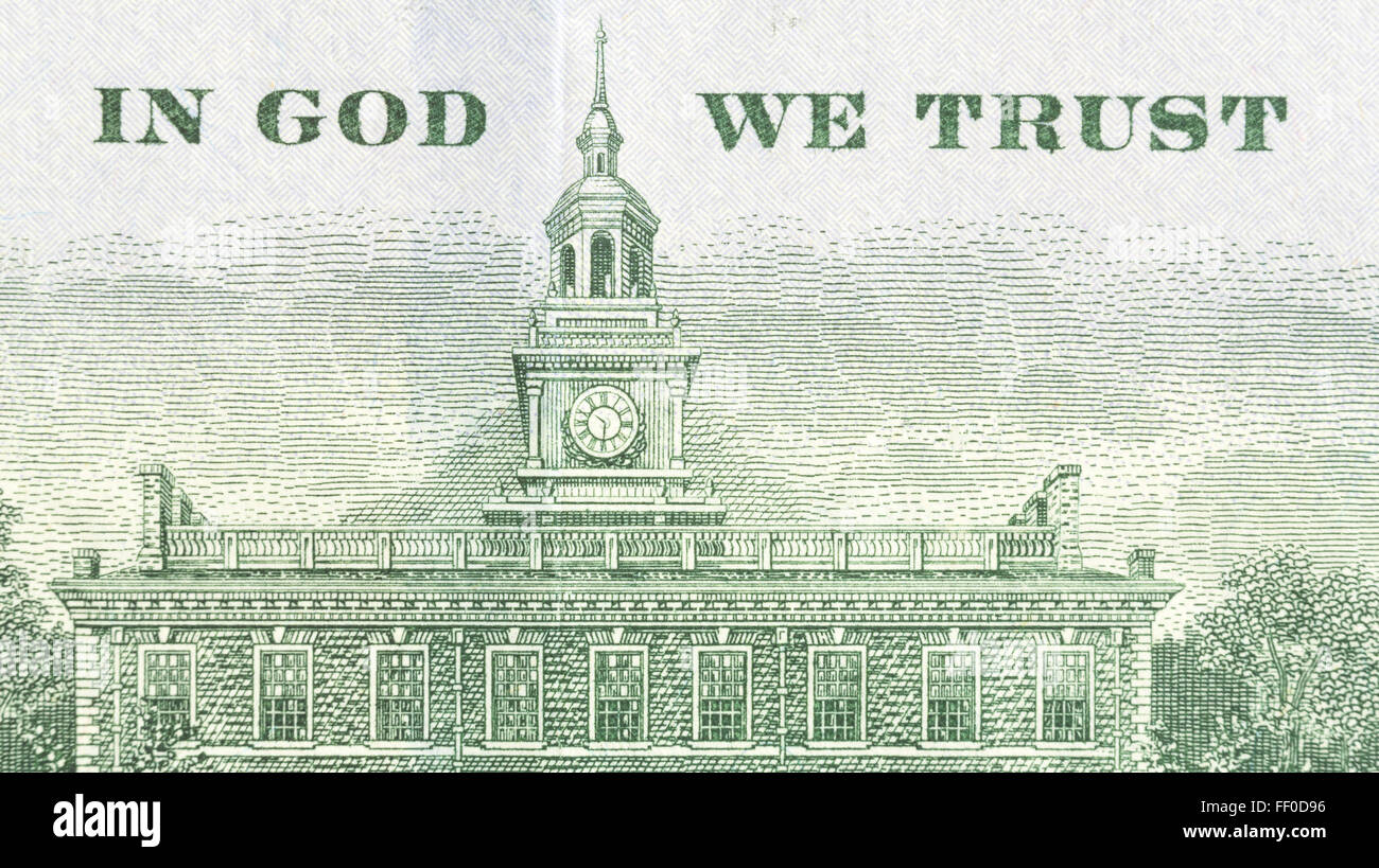 Close view of In God We Trust and Independence Hall on the back of an American hundred dollar