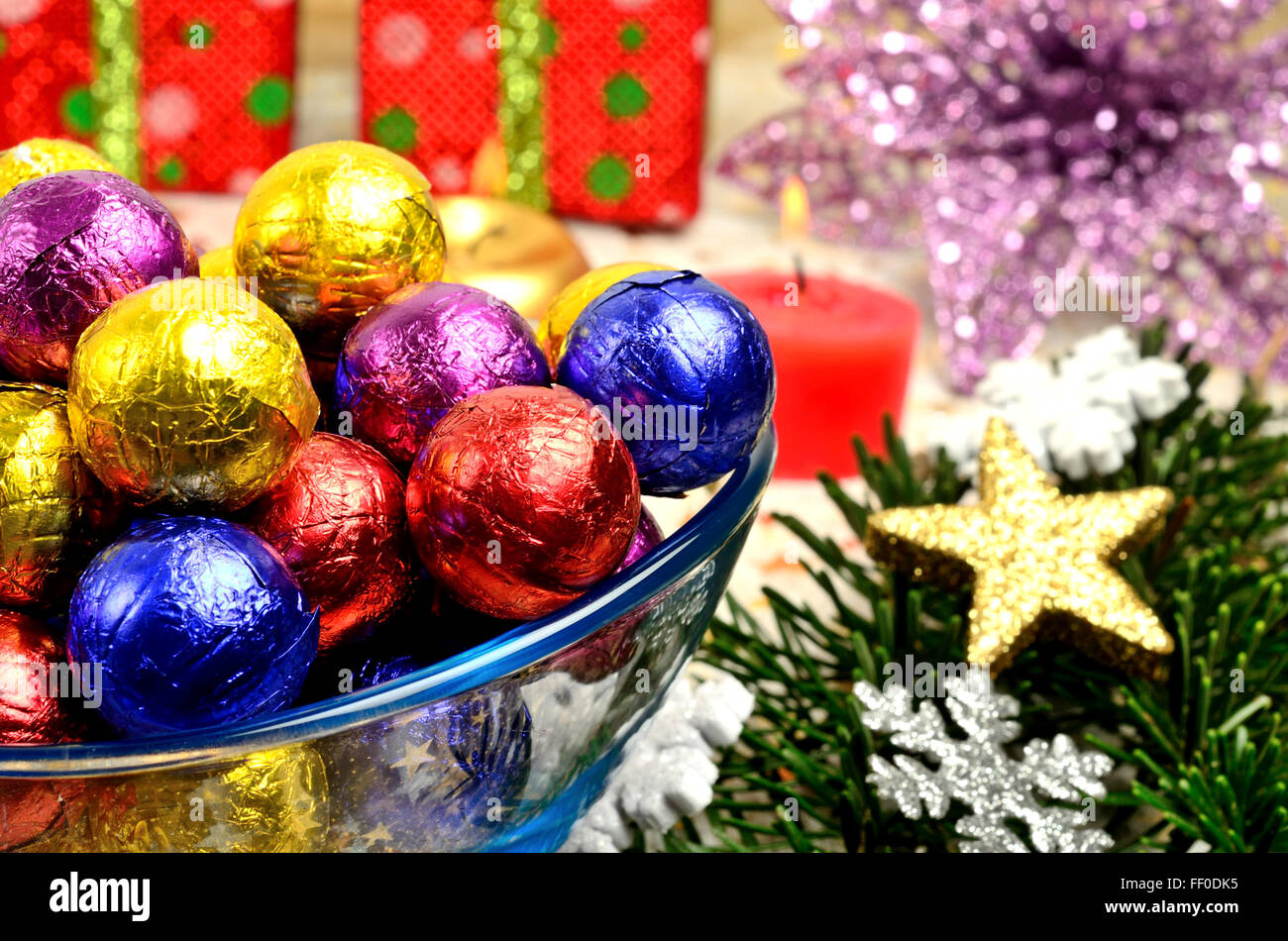 Bowl with colorful chocolate and christmas decoration on table Stock Photo