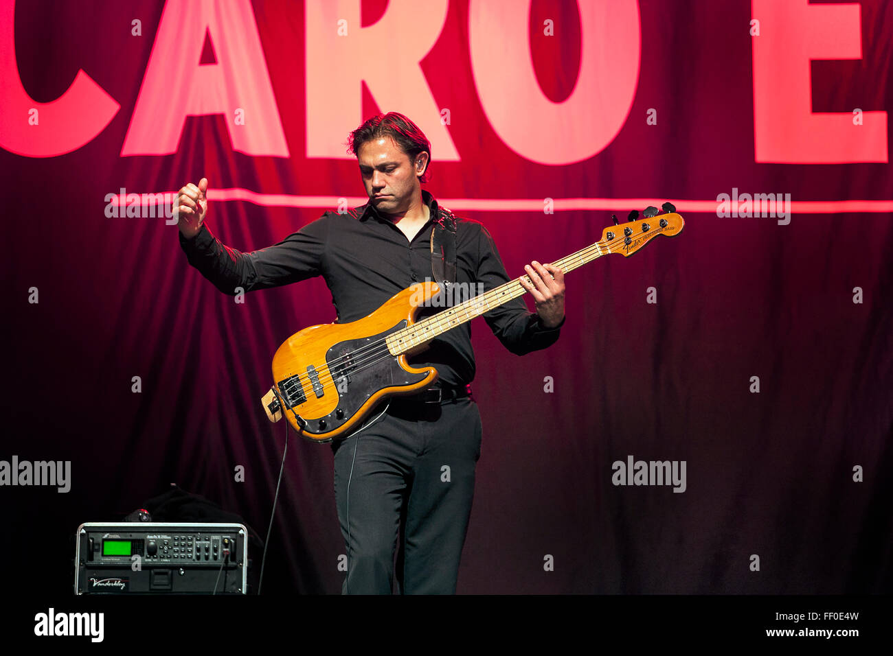A man playing a guitar with arm outstretched. Stock Photo