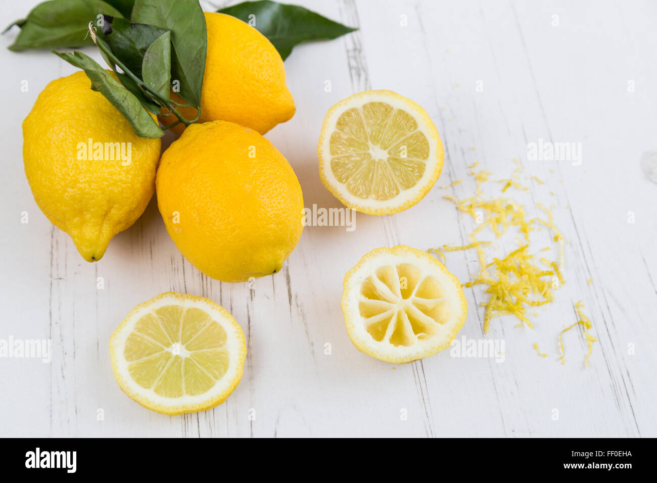Lemons, slices and zest on a white table Stock Photo