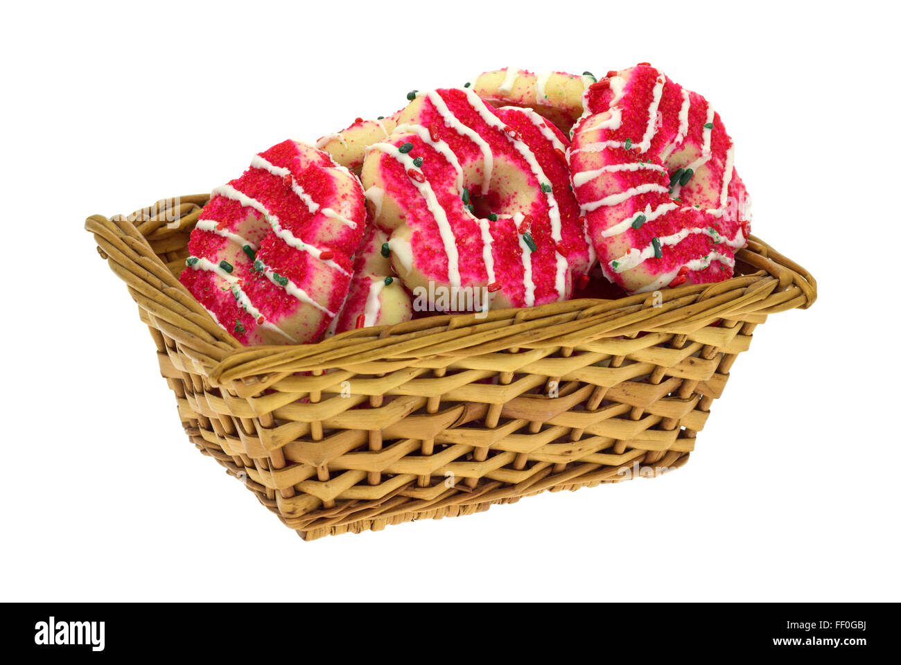 Several holiday decorated shortbread cookies in a small wicker basket isolated on a white background. Stock Photo