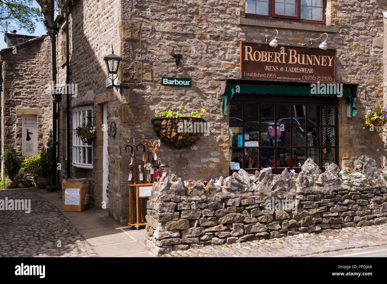 The exterior of an attractive, traditional, stone built, independent, clothing shop on Main Street, Grassington, North Yorkshire, England, UK. Stock Photo