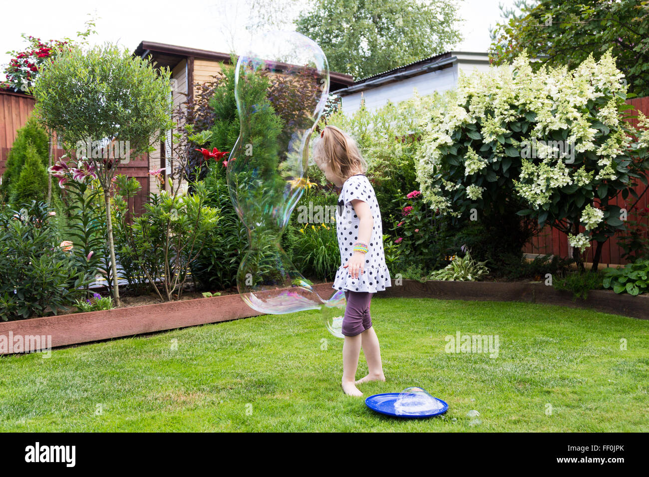 girl playing with soap bubbles in a beautiful garden Stock Photo - Alamy