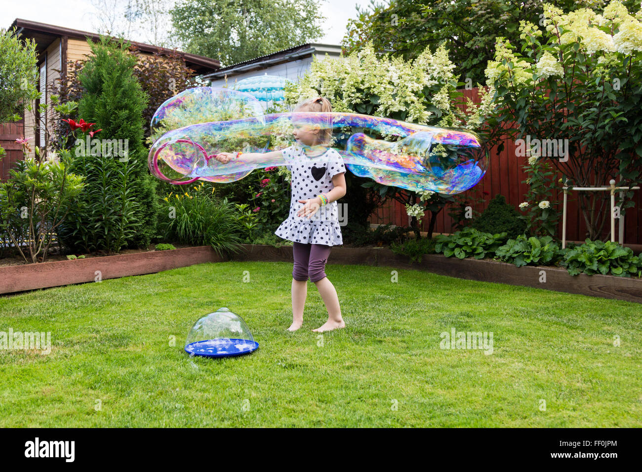 girl playing with soap bubbles in a beautiful garden Stock Photo - Alamy
