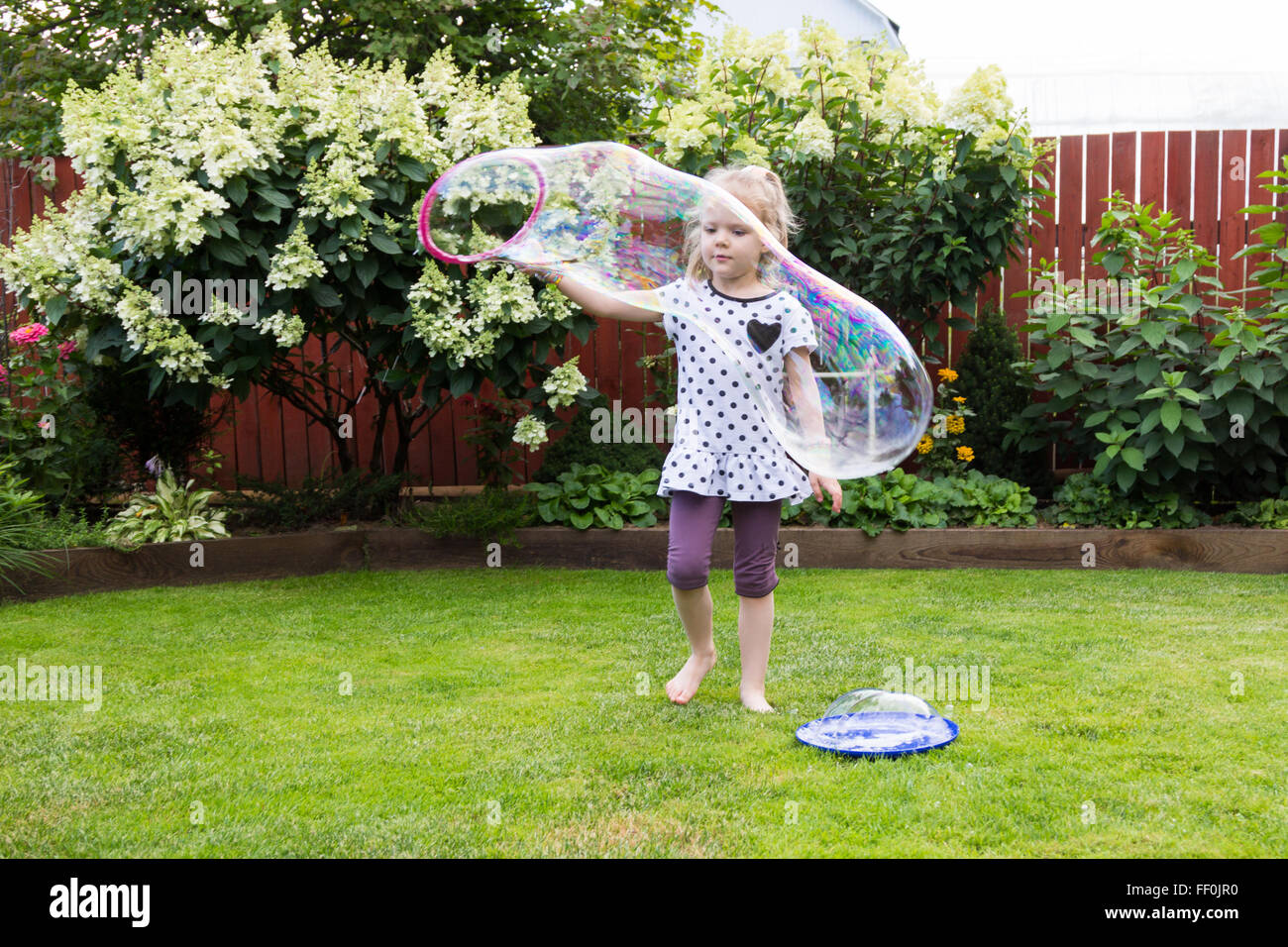 girl playing with soap bubbles in a beautiful garden Stock Photo - Alamy