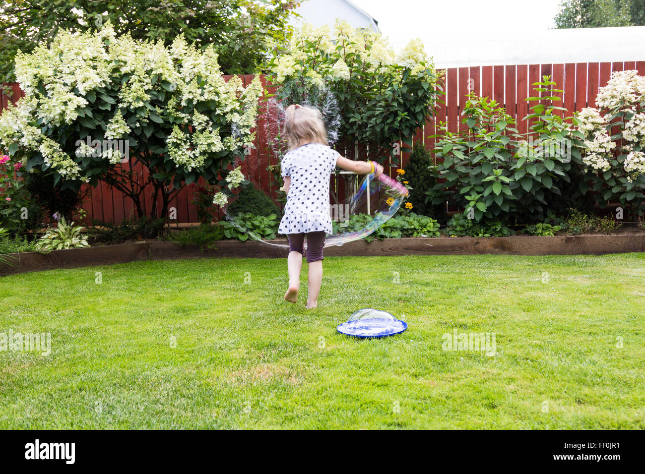 girl playing with soap bubbles in a beautiful garden Stock Photo - Alamy