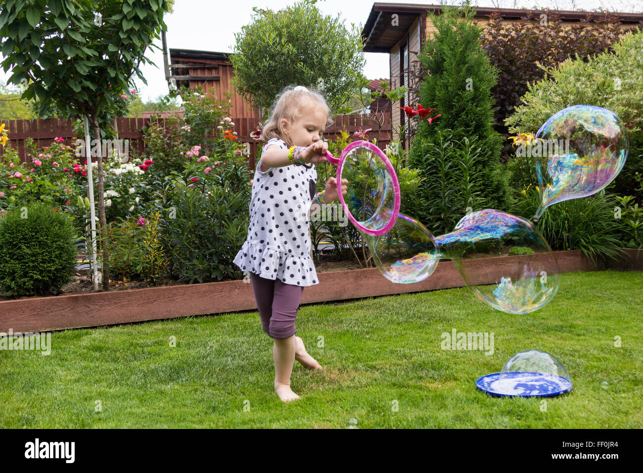girl playing with soap bubbles in a beautiful garden Stock Photo - Alamy