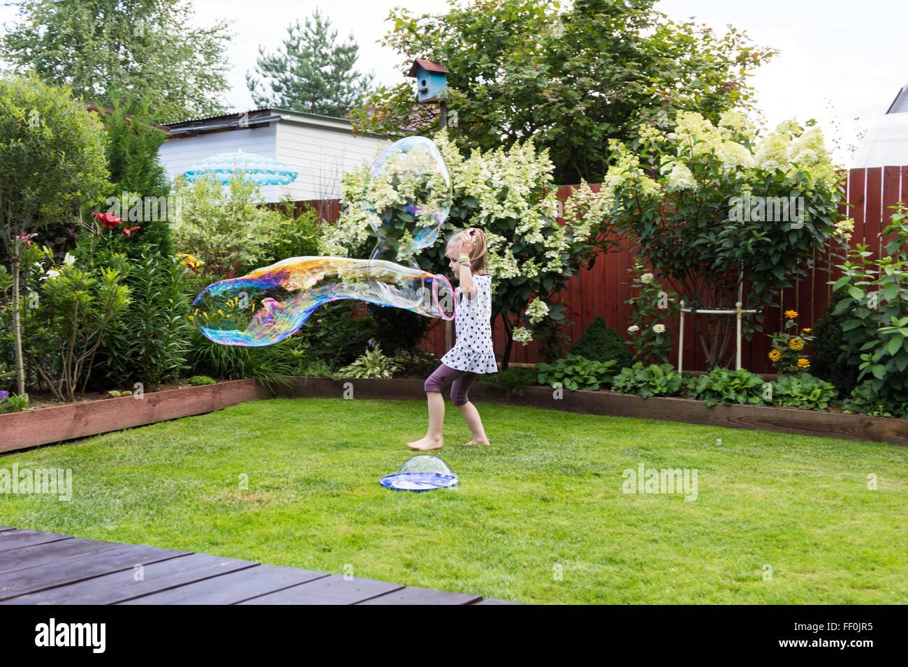 girl playing with soap bubbles in a beautiful garden Stock Photo - Alamy