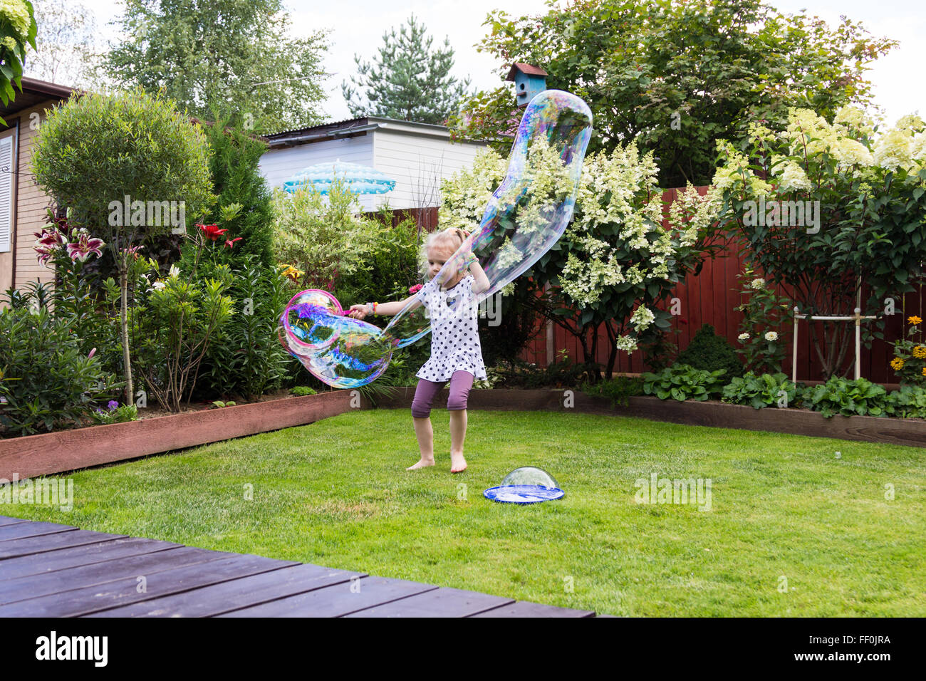 girl playing with soap bubbles in a beautiful garden Stock Photo - Alamy