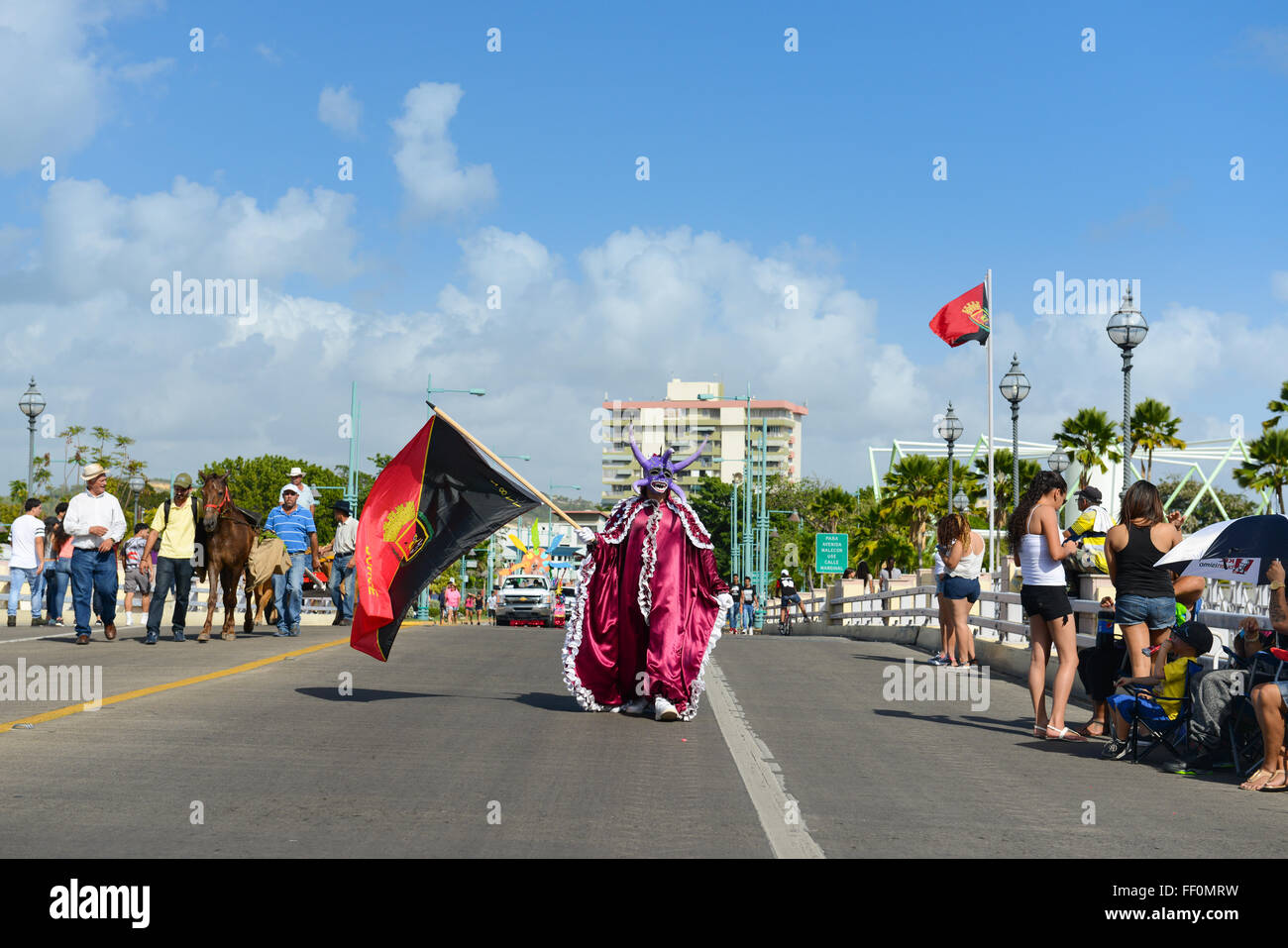 Traditional masked cultural figure VEJIGANTE caring the flag of Ponce during carnival. Ponce, Puerto Rico. February 2016 Stock Photo