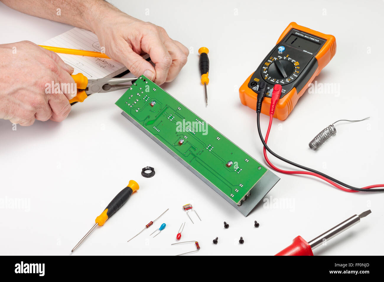 Electronics engineer at his workbench using long nose pliers on a circuit board Stock Photo Alamy