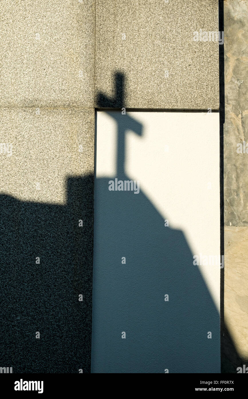 Shadow of a cross on a  cemetry wall Stock Photo