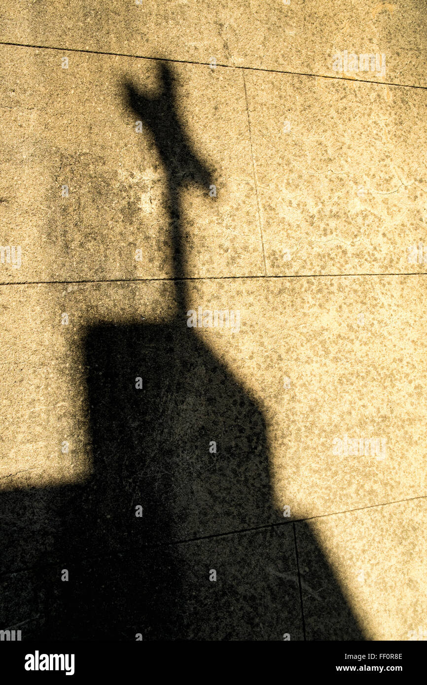 Shadow of a cross on a  cemetry wall Stock Photo