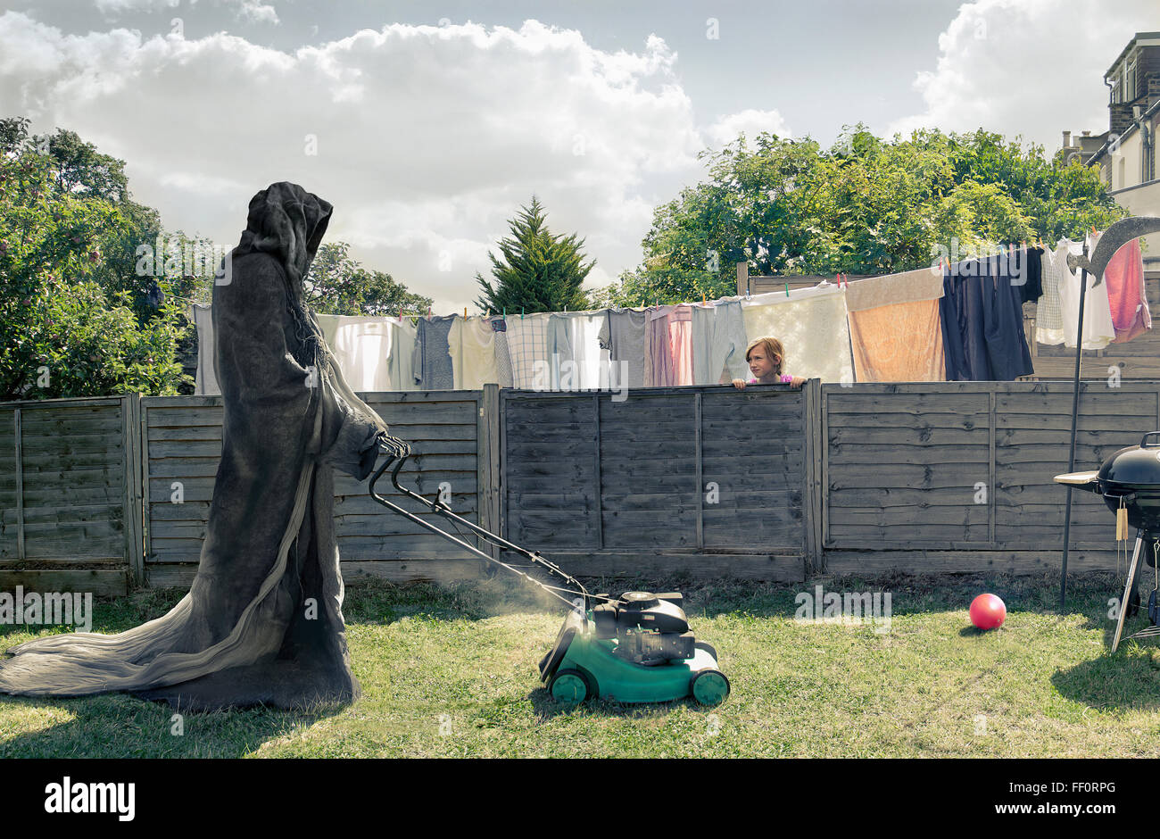 Grim Reaper mowing backyard Stock Photo