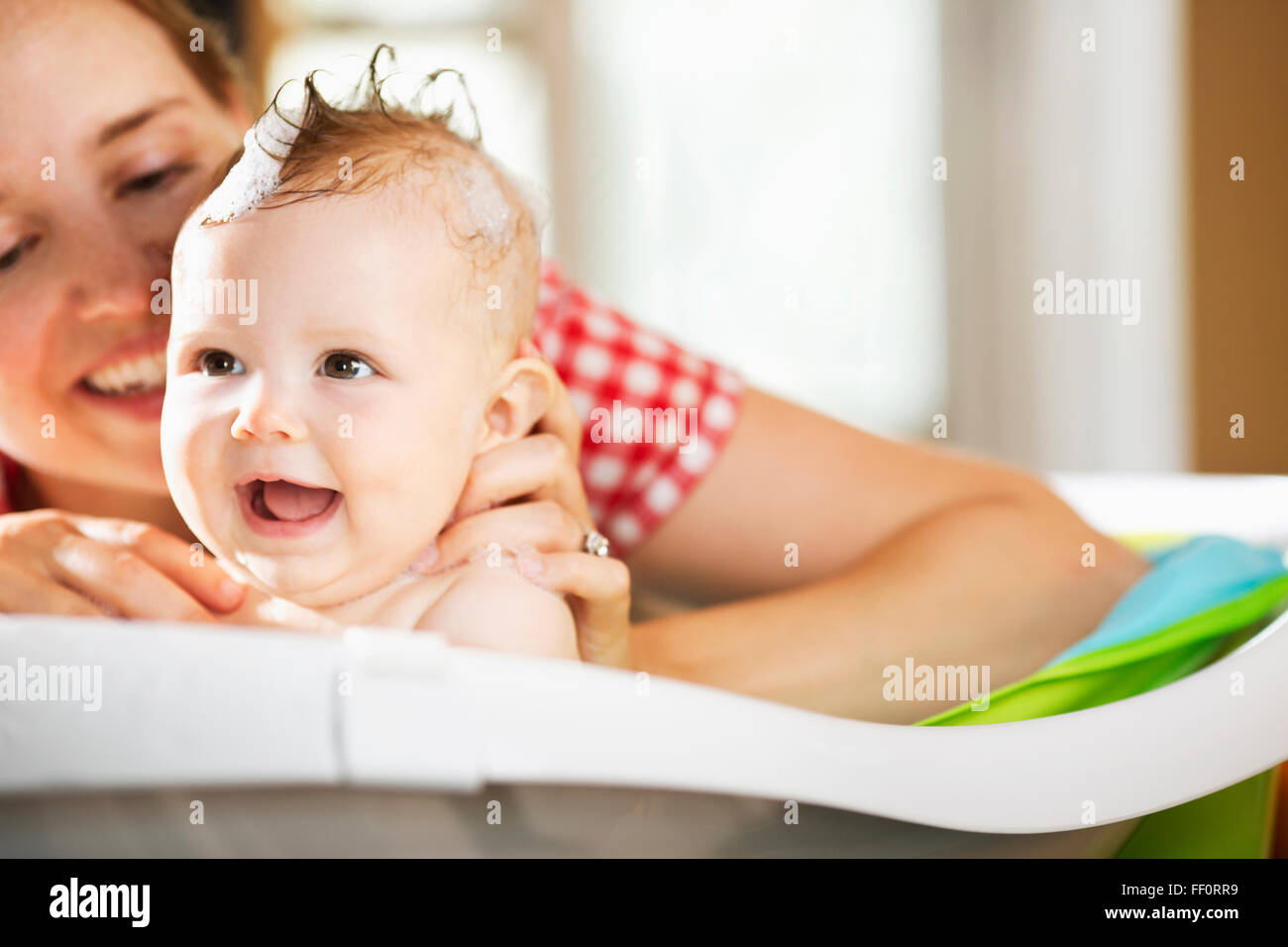 Caucasian mother bathing baby daughter Stock Photo