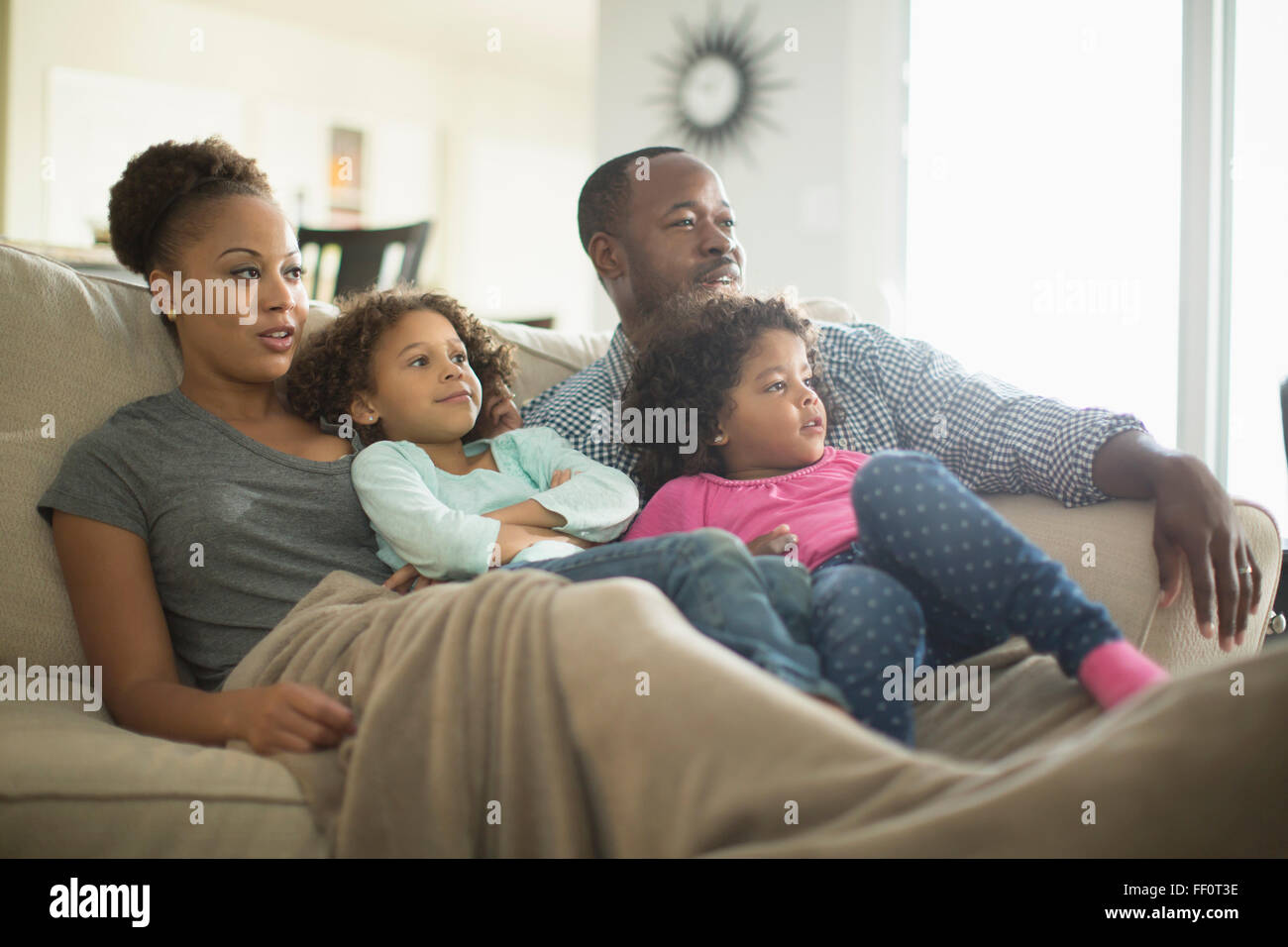 Family watching television on sofa Stock Photo