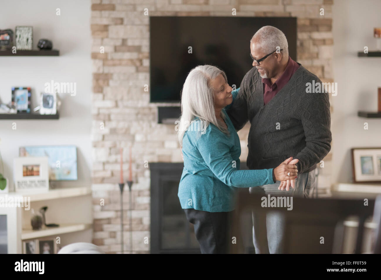 Older couple dancing in living room Stock Photo