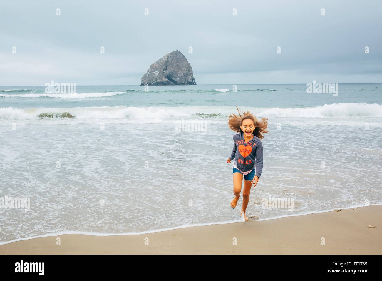 Mixed race girl running on beach Stock Photo Alamy