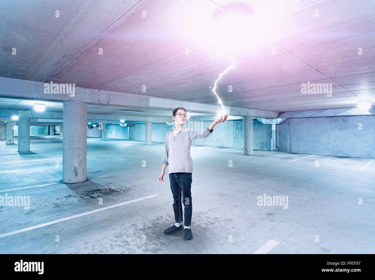 Mixed race boy holding lightning in parking lot Stock Photo