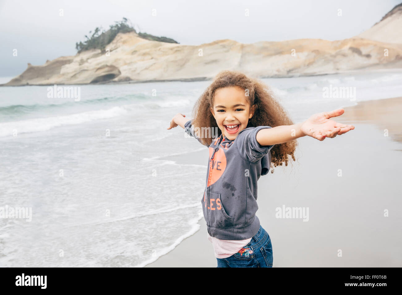 Mixed race girl playing on beach Stock Photo Alamy