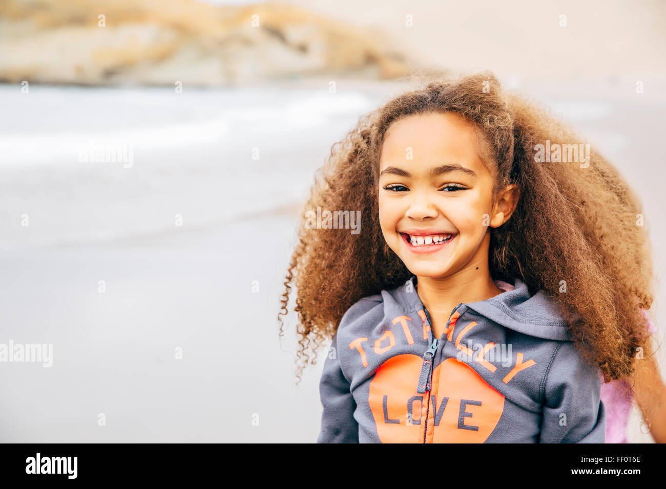 Mixed race girl smiling on beach Stock Photo Alamy