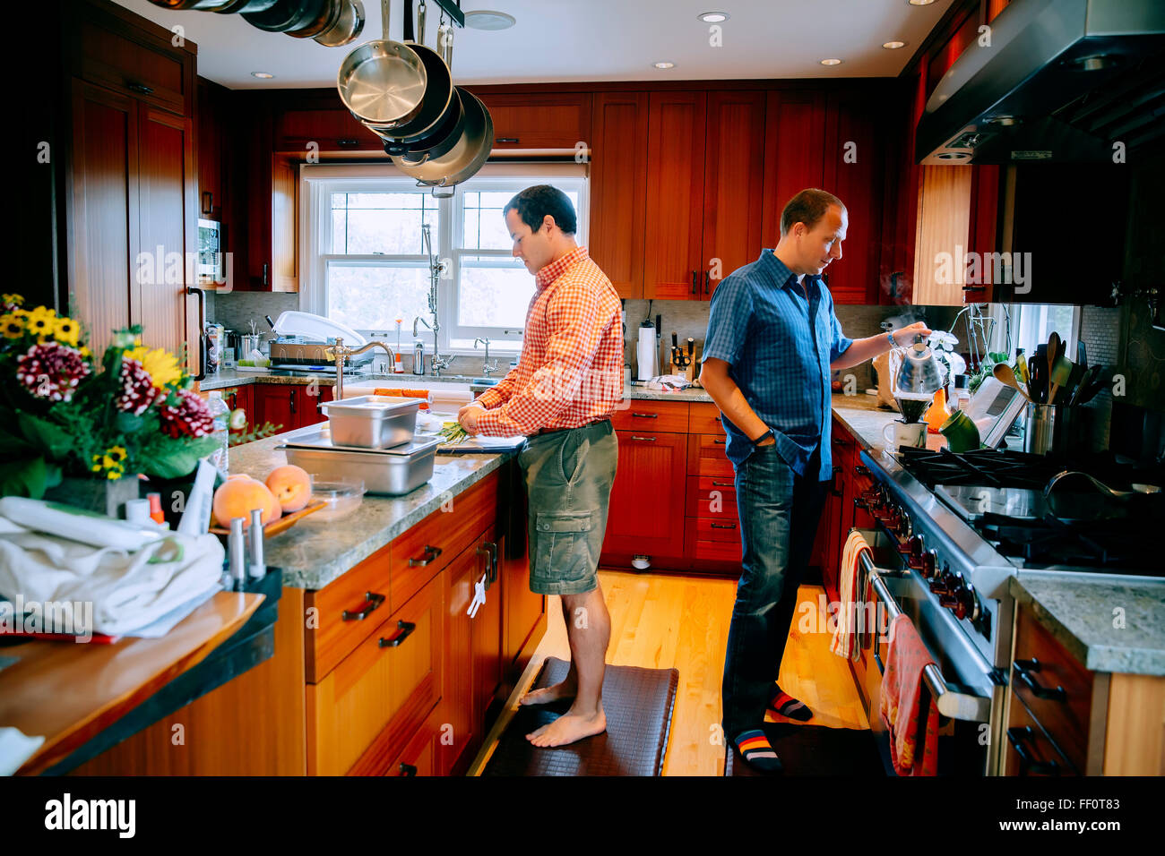 Caucasian gay couple cooking in kitchen Stock Photo