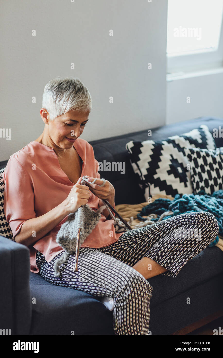 Older Caucasian woman knitting on sofa Stock Photo - Alamy