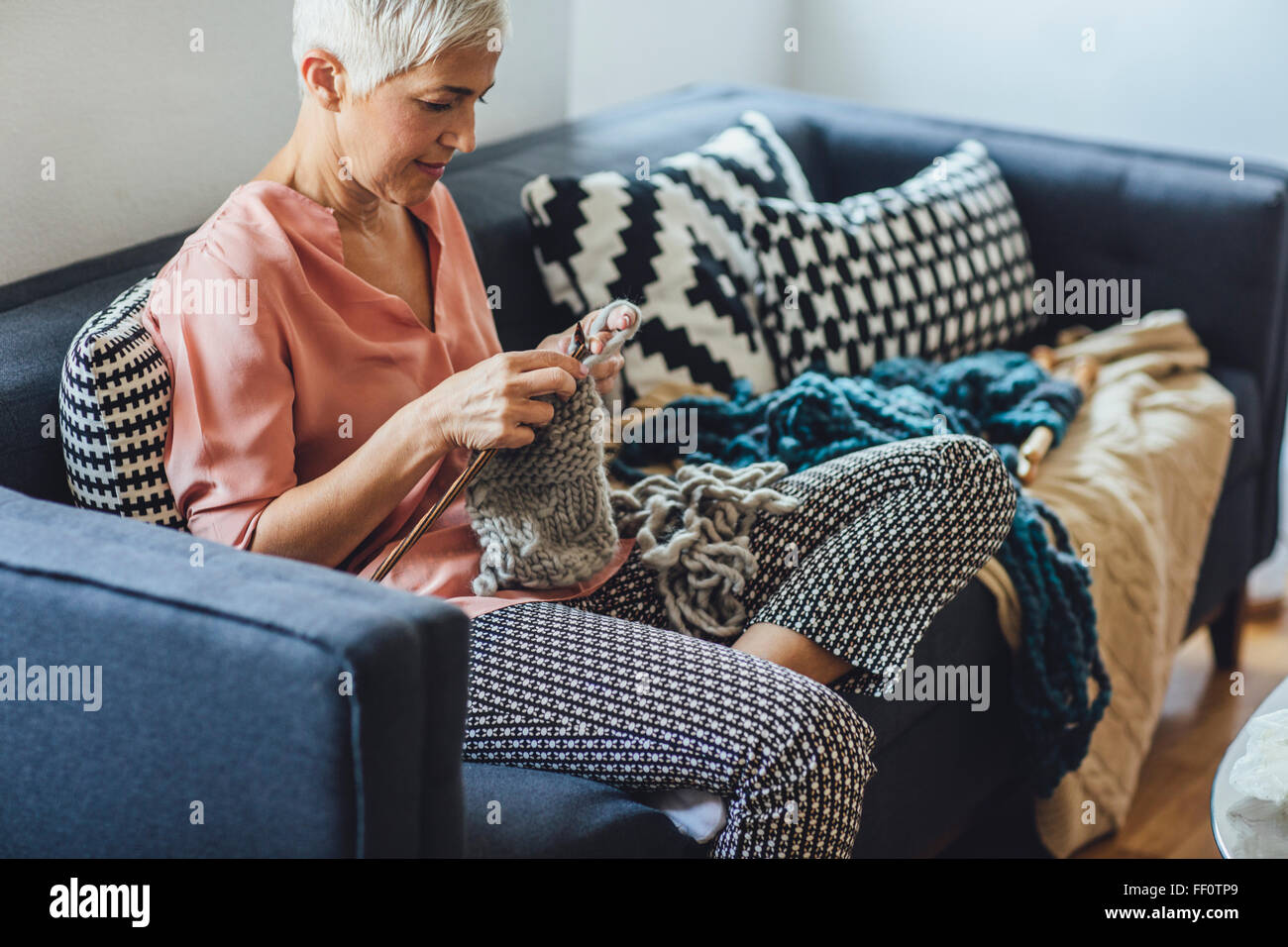 Older Caucasian woman knitting on sofa Stock Photo - Alamy