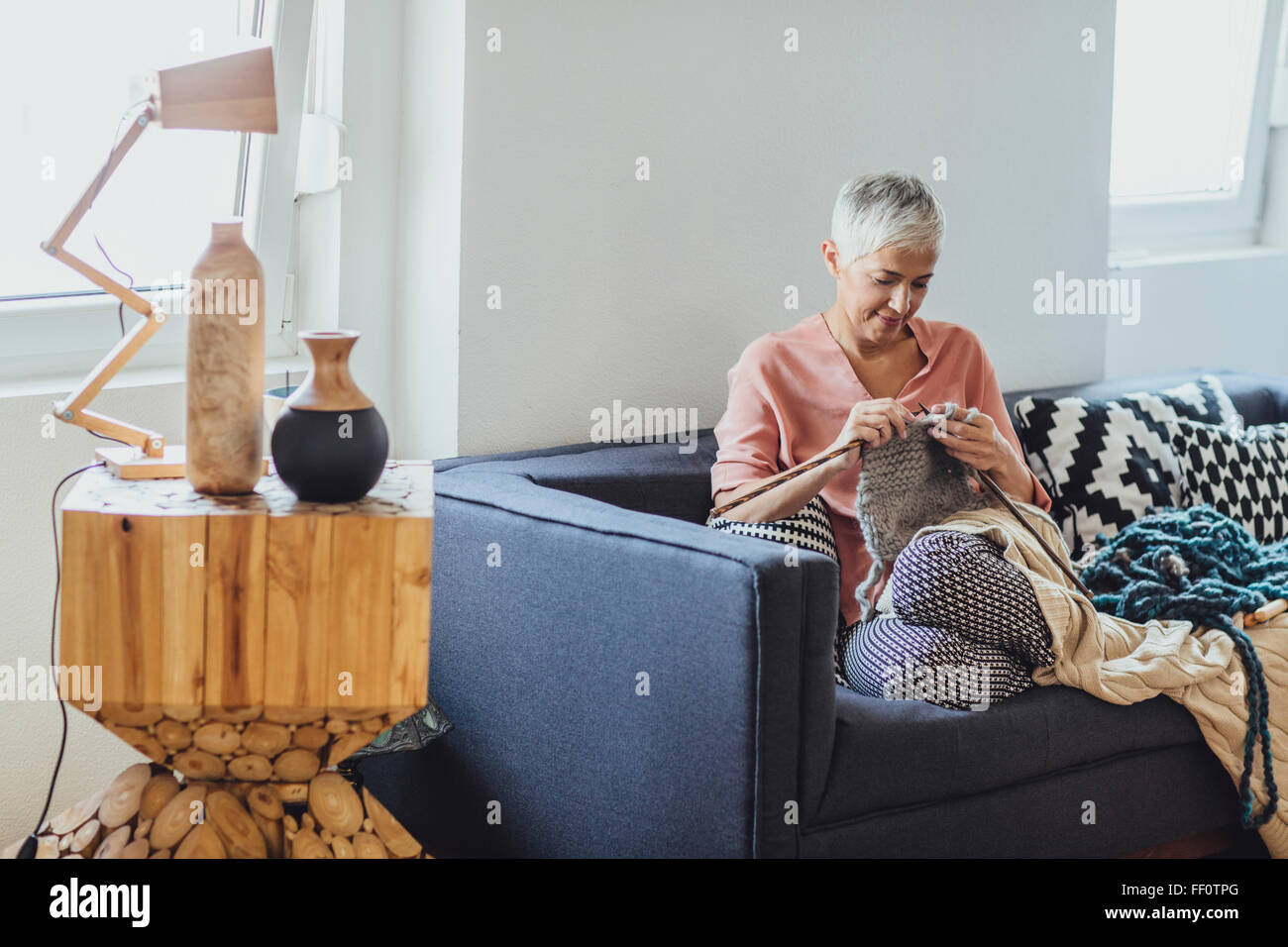 Older Caucasian woman knitting on sofa Stock Photo - Alamy